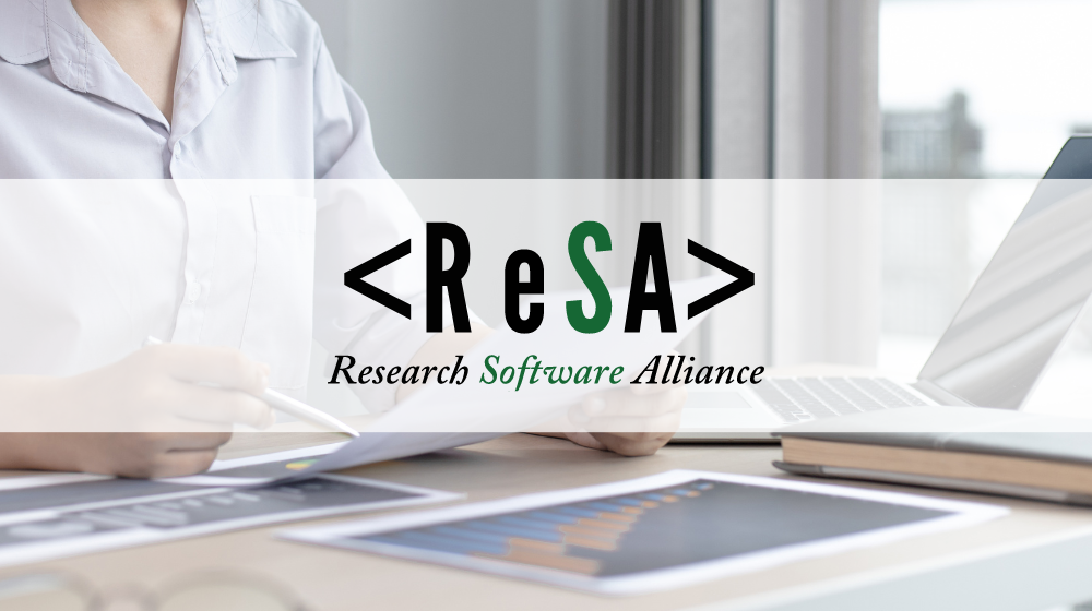 A person sitting at a desk reading a document, the ReSA logo
