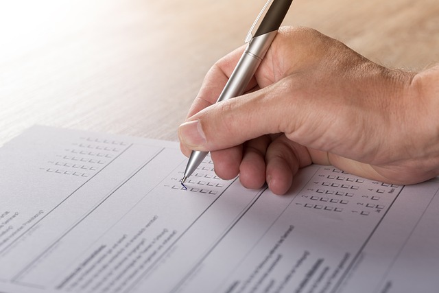A hand holding a pen over a printed survey