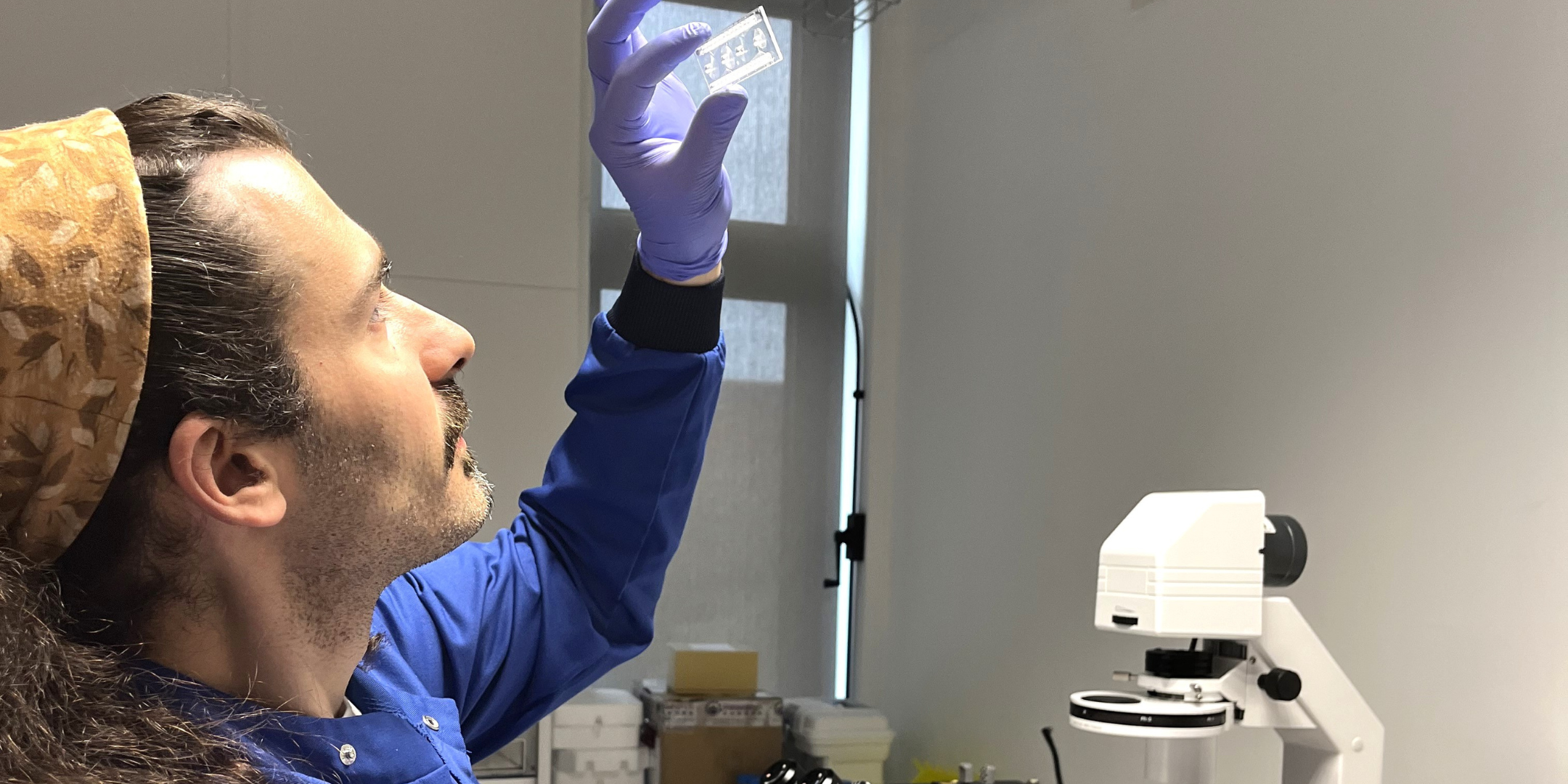 A man holding a microscope slide