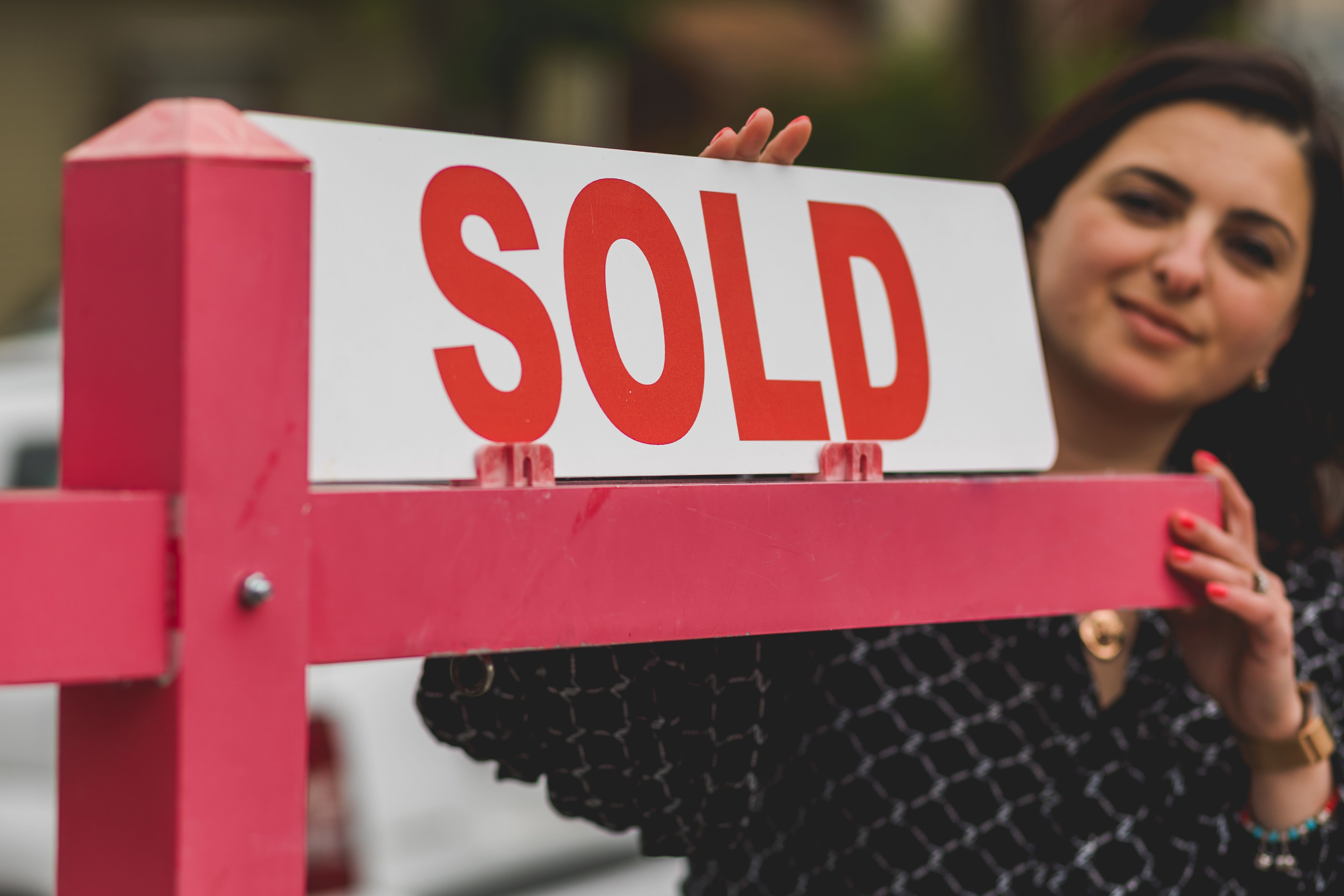 Estate agent holding a sold sign