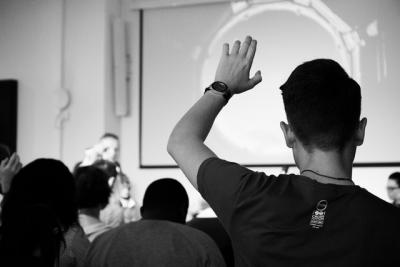 man with raised hand in classroom