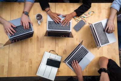 people around a table with laptops