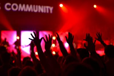 raised hands in front of a sign saying community